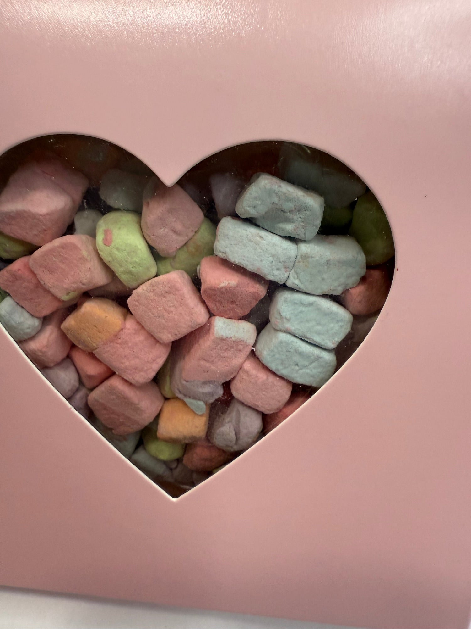Heart-shaped pink box window with freeze dried marshmallow charms inside