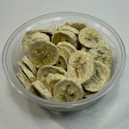 Clear plastic container filled with sliced freeze dried bananas on a white background