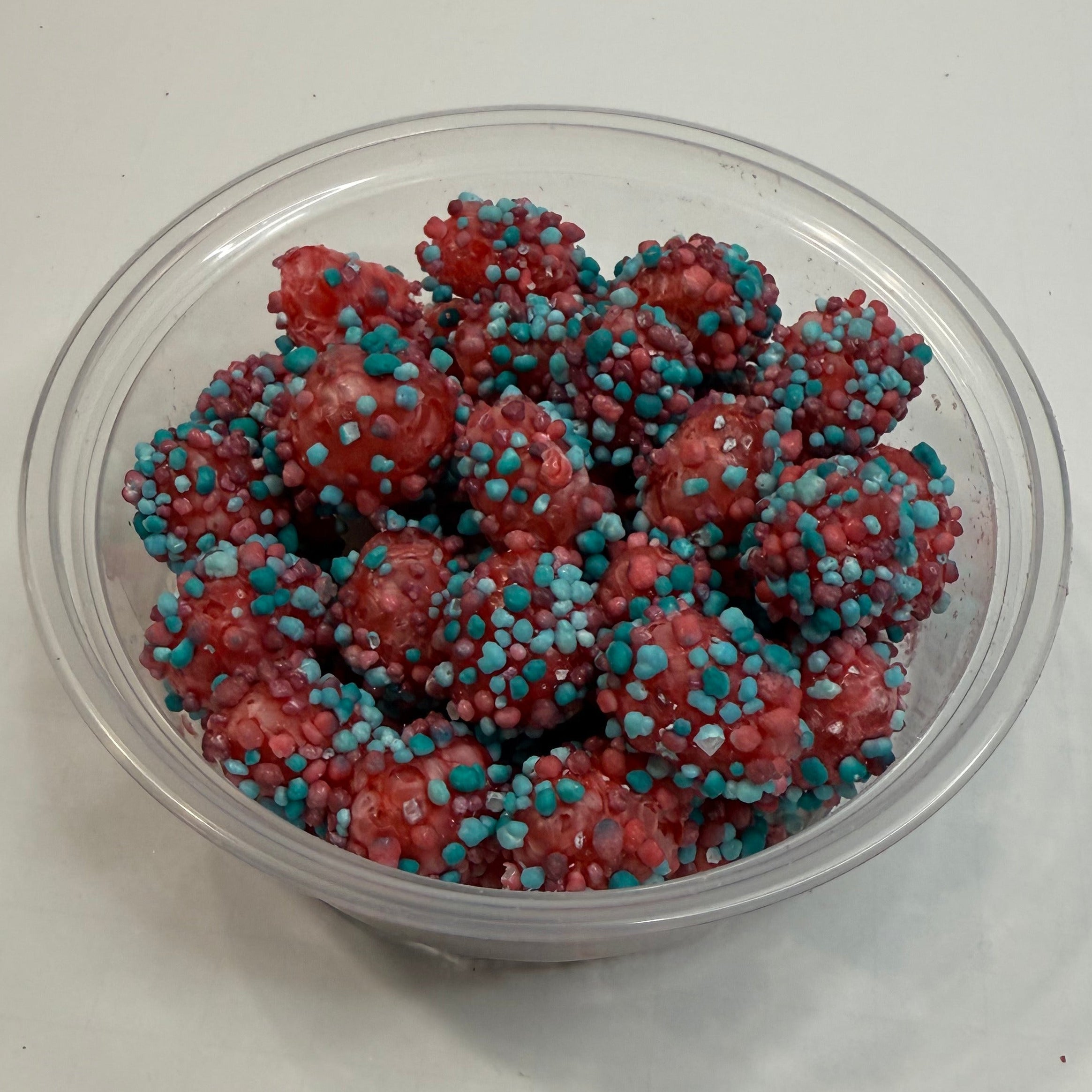 Clear container with freeze dried berry blue nerds gummy clusters on a white background