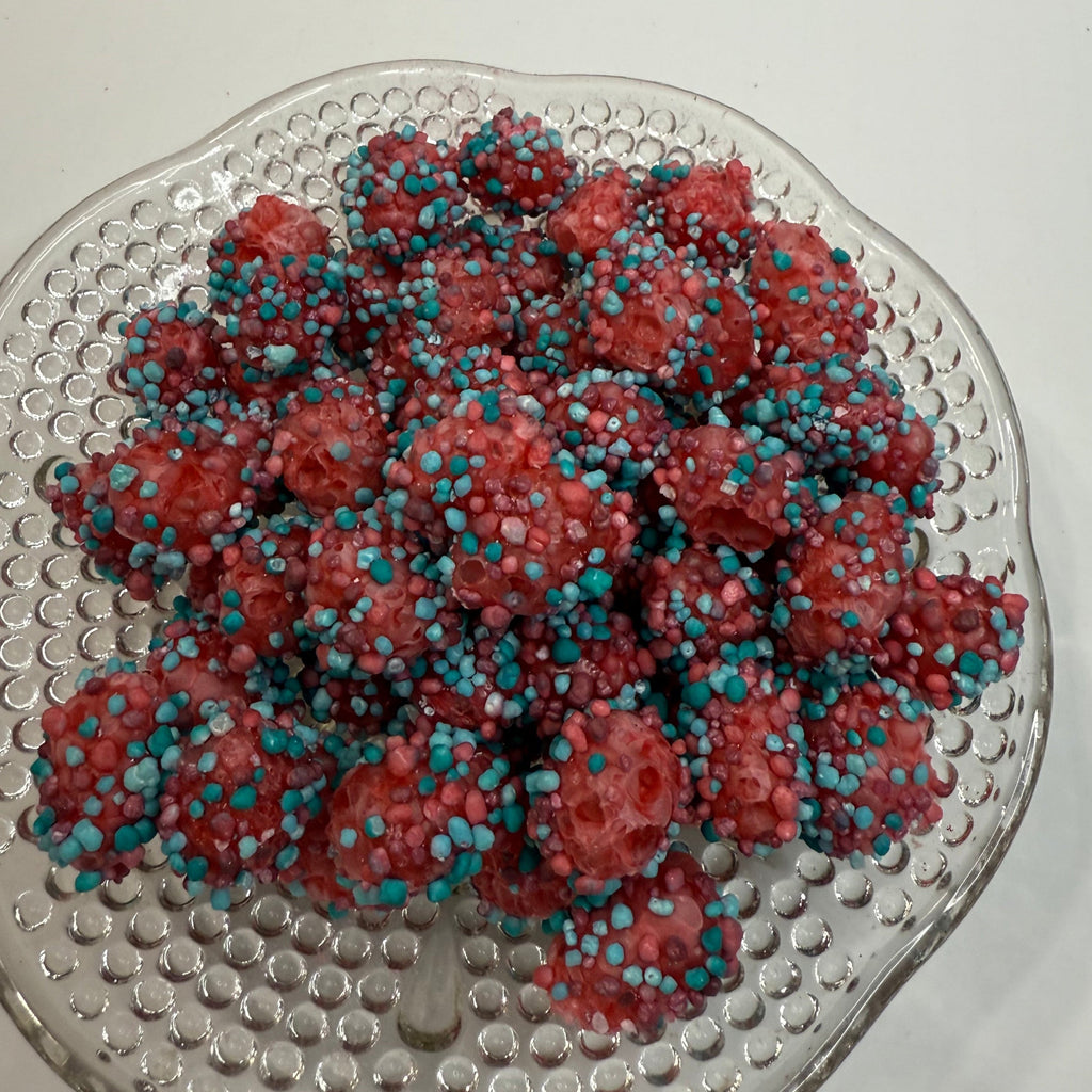 Freeze Dried Berry Blue Raspberry Nerds Gummy Clusters on a textured glass plate against a plain background