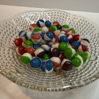 Freeze dried berry skittles on a clear glass plate with a white background