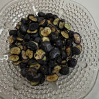 Freeze dried blueberries on a textured glass plate
