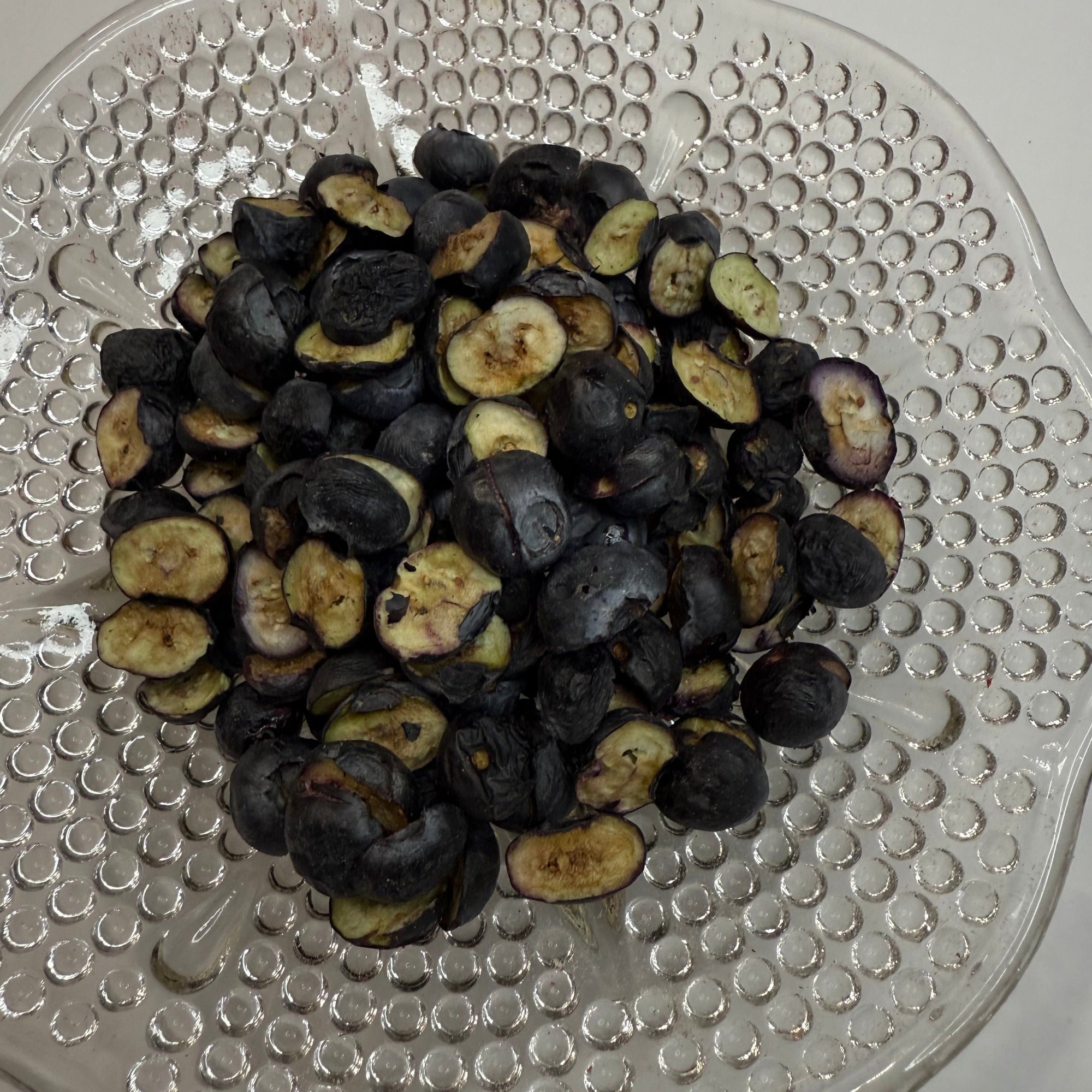 Freeze dried blueberries on a textured glass plate