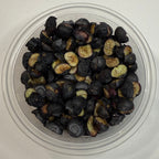 Small container with freeze dried blueberries on a white background