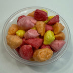 Clear plastic container with freeze dried starbursts on a white surface