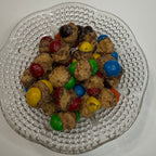 Clear glass plate with freeze dried caramel m&ms on a white surface