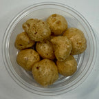 Clear plastic container with freeze dried caramel on a white background