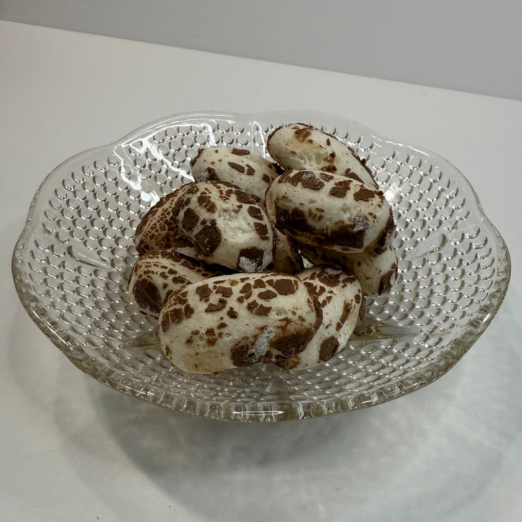 Decorative glass plate with freeze dried chocolate chews on a white surface