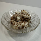 Decorative glass plate with freeze dried chocolate chews on a white surface