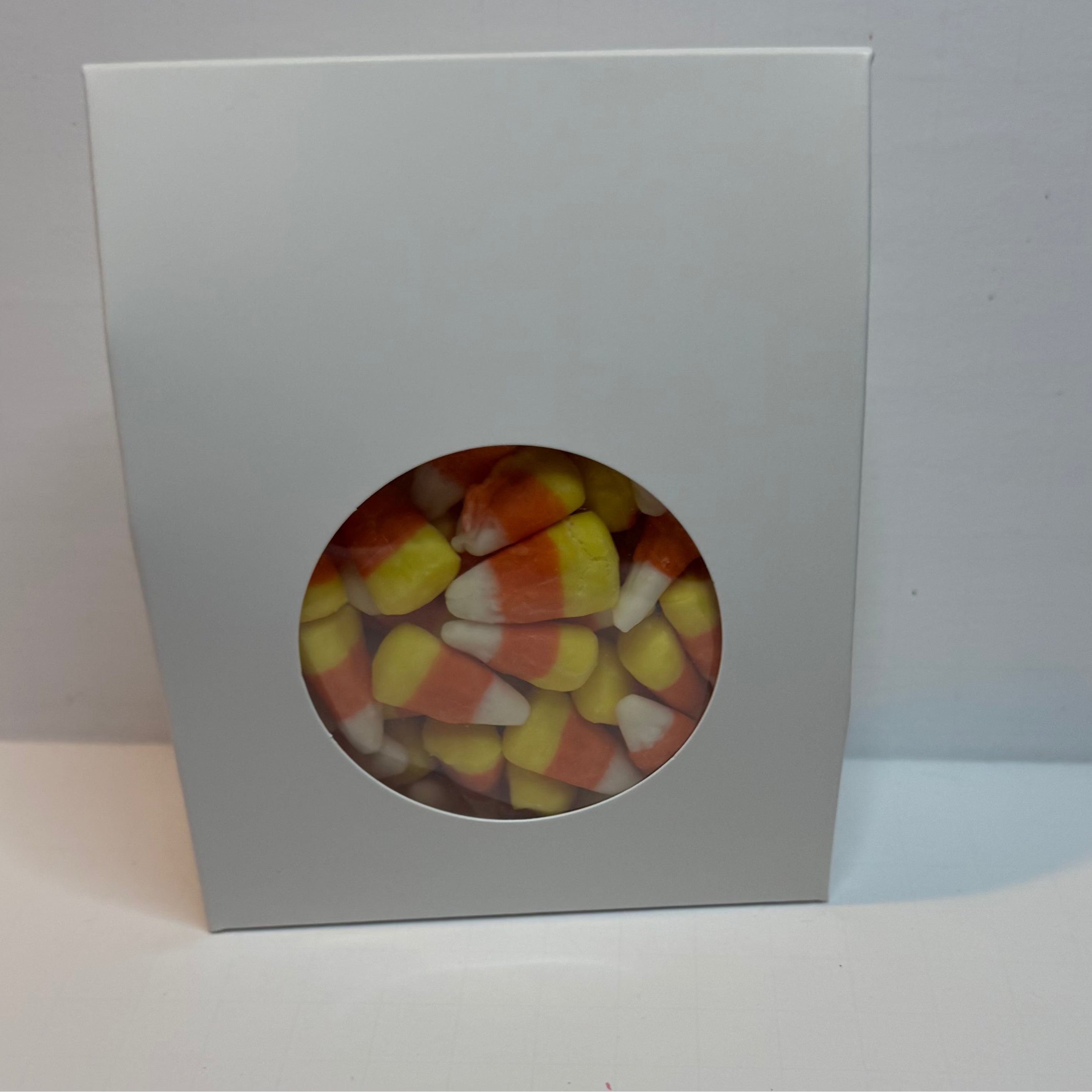 White box with a clear window containing colorful candy on a white background