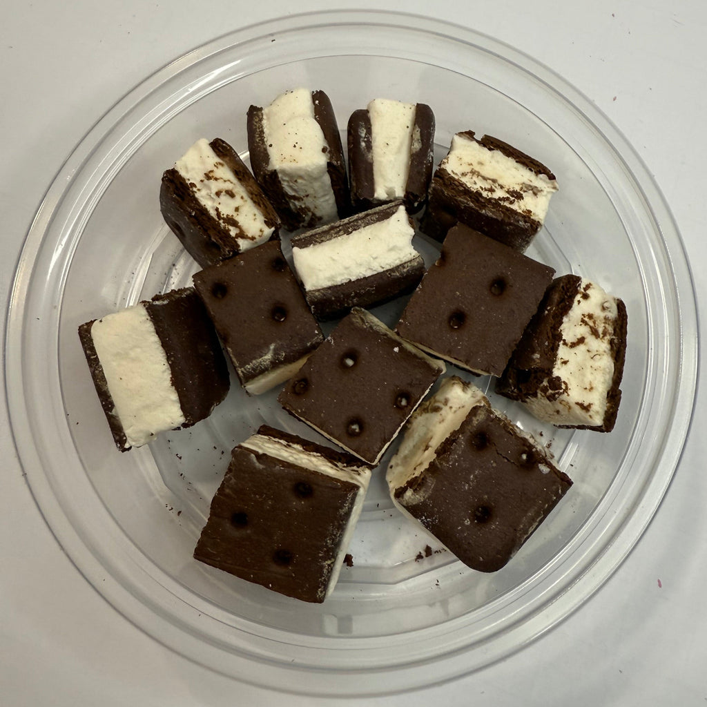 Freeze dried ice cream sandwich bites in a clear container on a white background