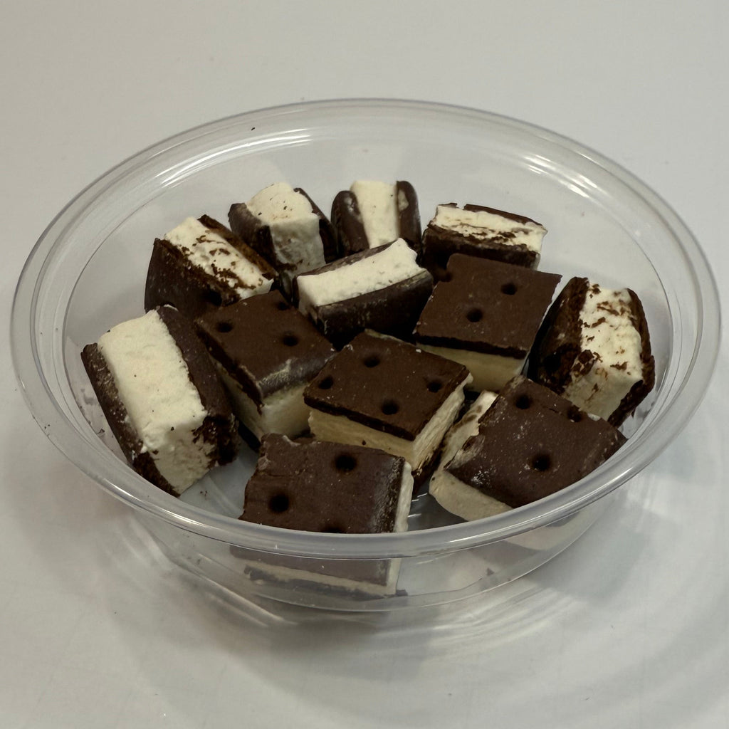 Clear plastic container with freeze dried ice cream sandwich bites on a white background