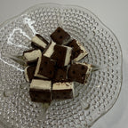 Freeze dried chocolate and vanilla ice cream sandwich bites on a decorative glass plate.