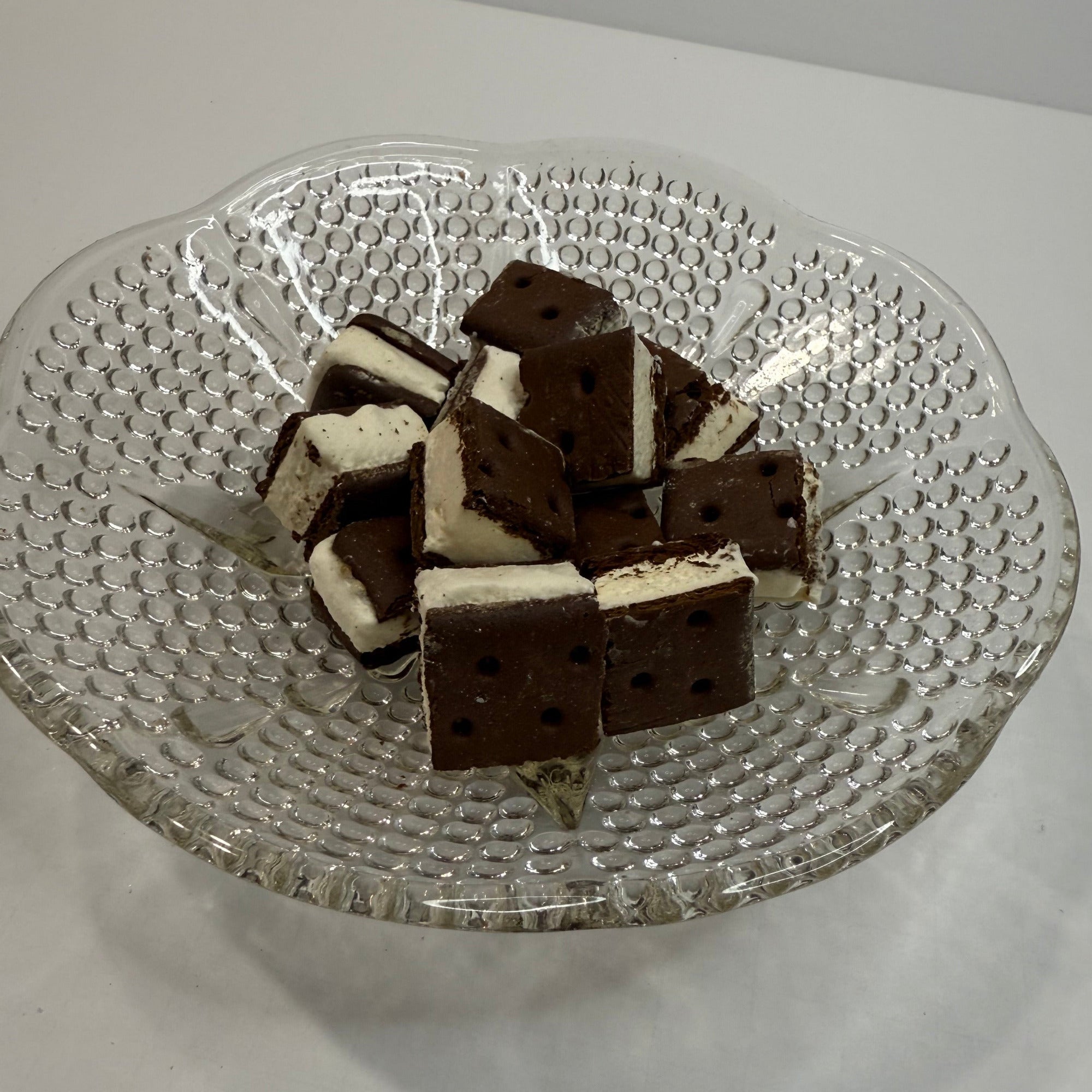Glass plate with freeze dried ice cream sandwich bites on a white background