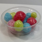 Clear plastic container filled with freeze dried jolly ranchers on a white background
