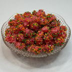 Clear glass dish filled with freeze dried nerds gummy clusters on a white surface.