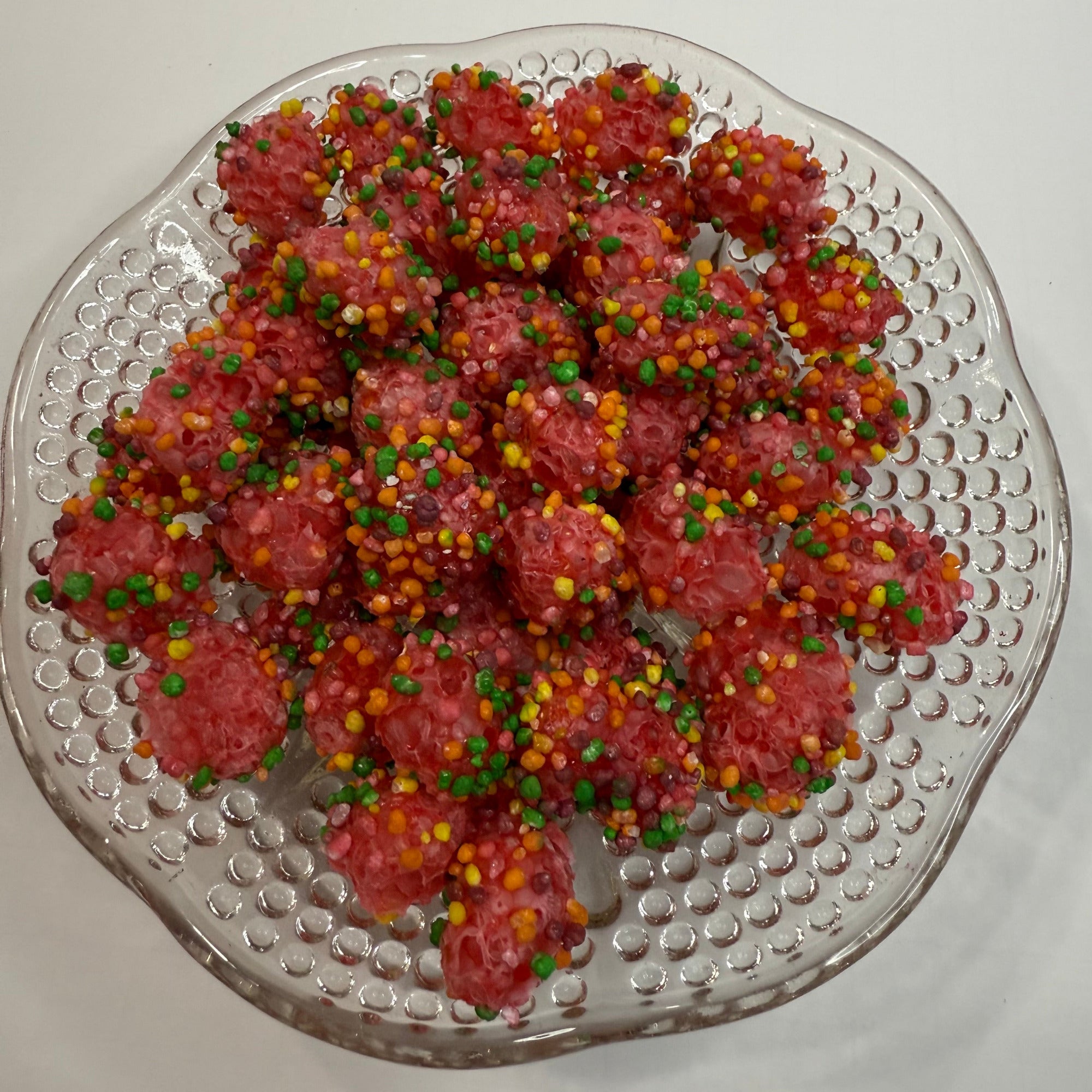 Freeze dried nerds gummy clusters on a textured glass plate.