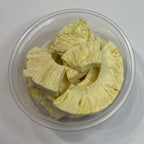 Clear container with freeze dried pineapple on a white background