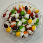 Freeze dried skittles in a clear plastic container on a white background