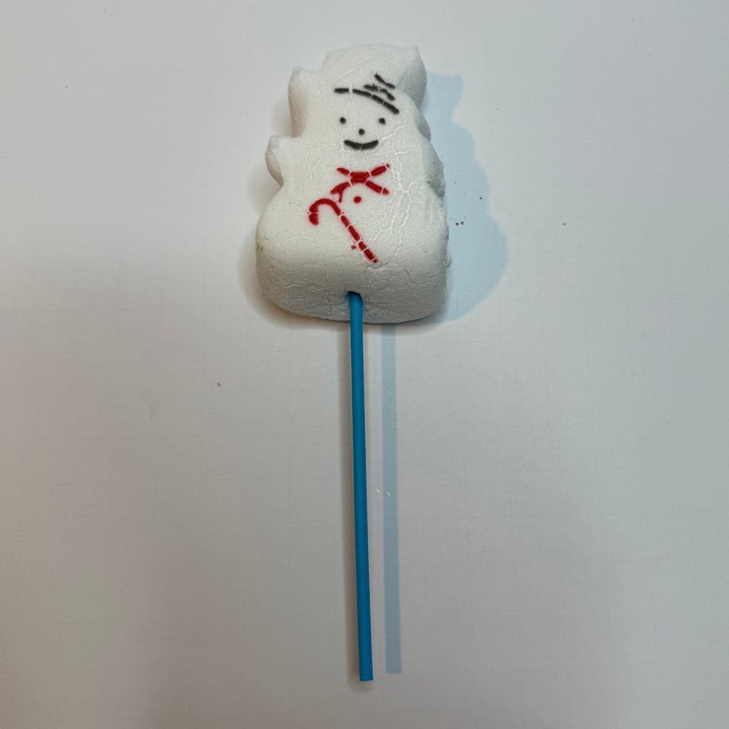 Freeze dried snowman peep on a stick against a white background