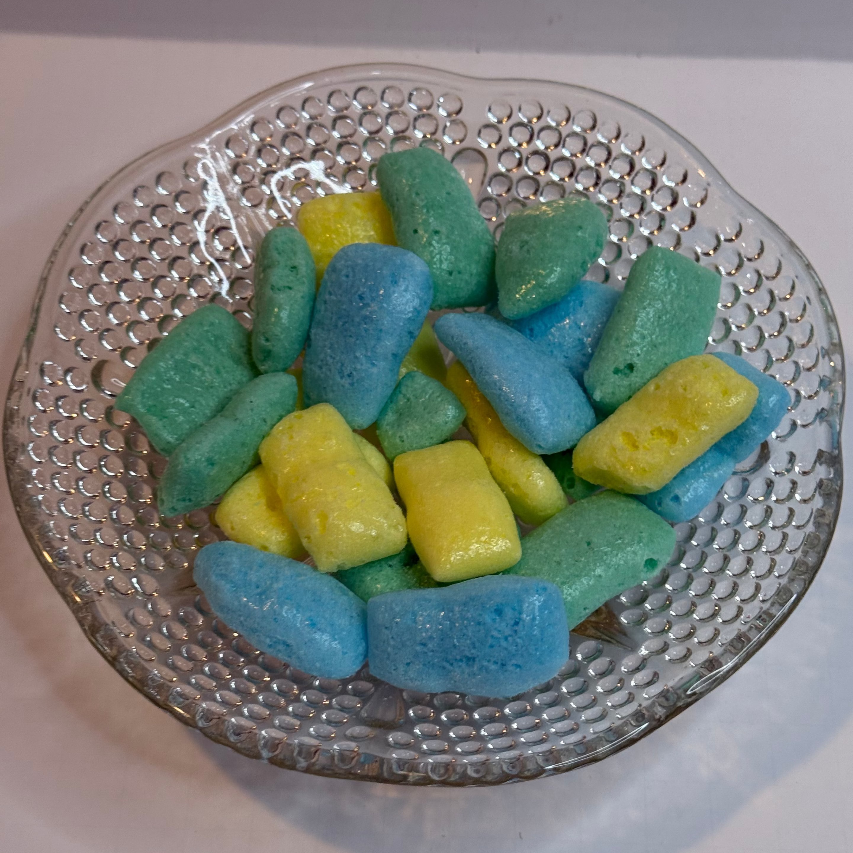 Freeze dried sour air headz in a glass bowl on a white background