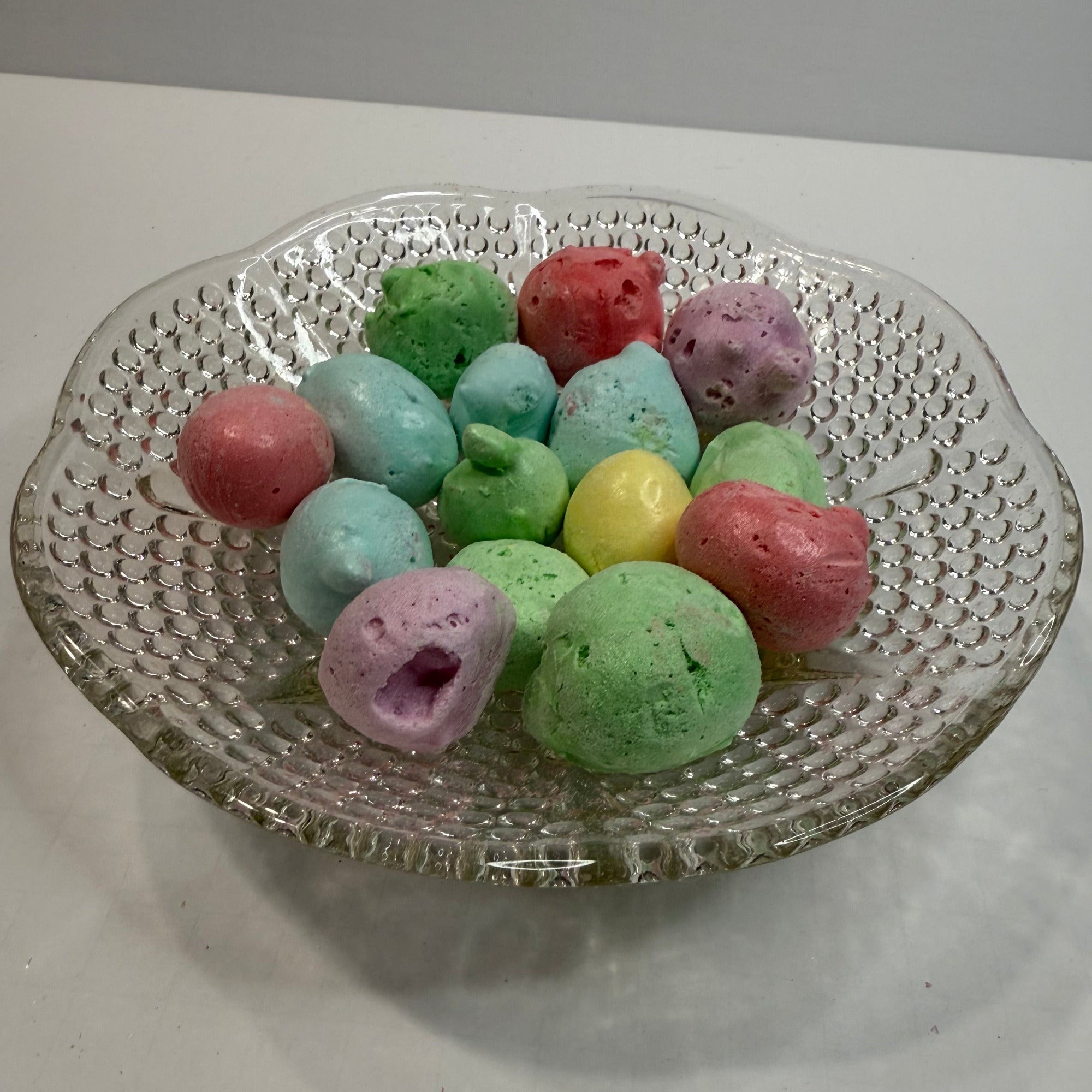 Freeze dried sour salt water taffy on a decorative glass plate with a plain background