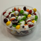 Container of freeze dried sour skittles on a white surface