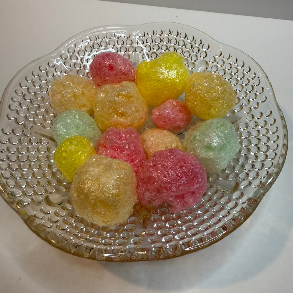 Freeze dried tropical Jolly Ranchers on a textured glass plate with a white background