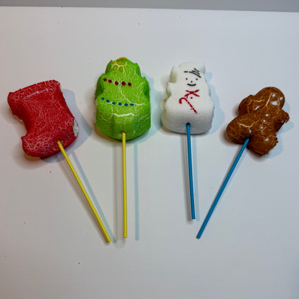 Five freeze dried xmas peeps on sticks against a white background