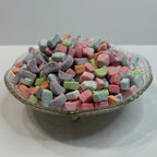 Textured glass bowl with colorful freeze dried marshmallow charms on a white background