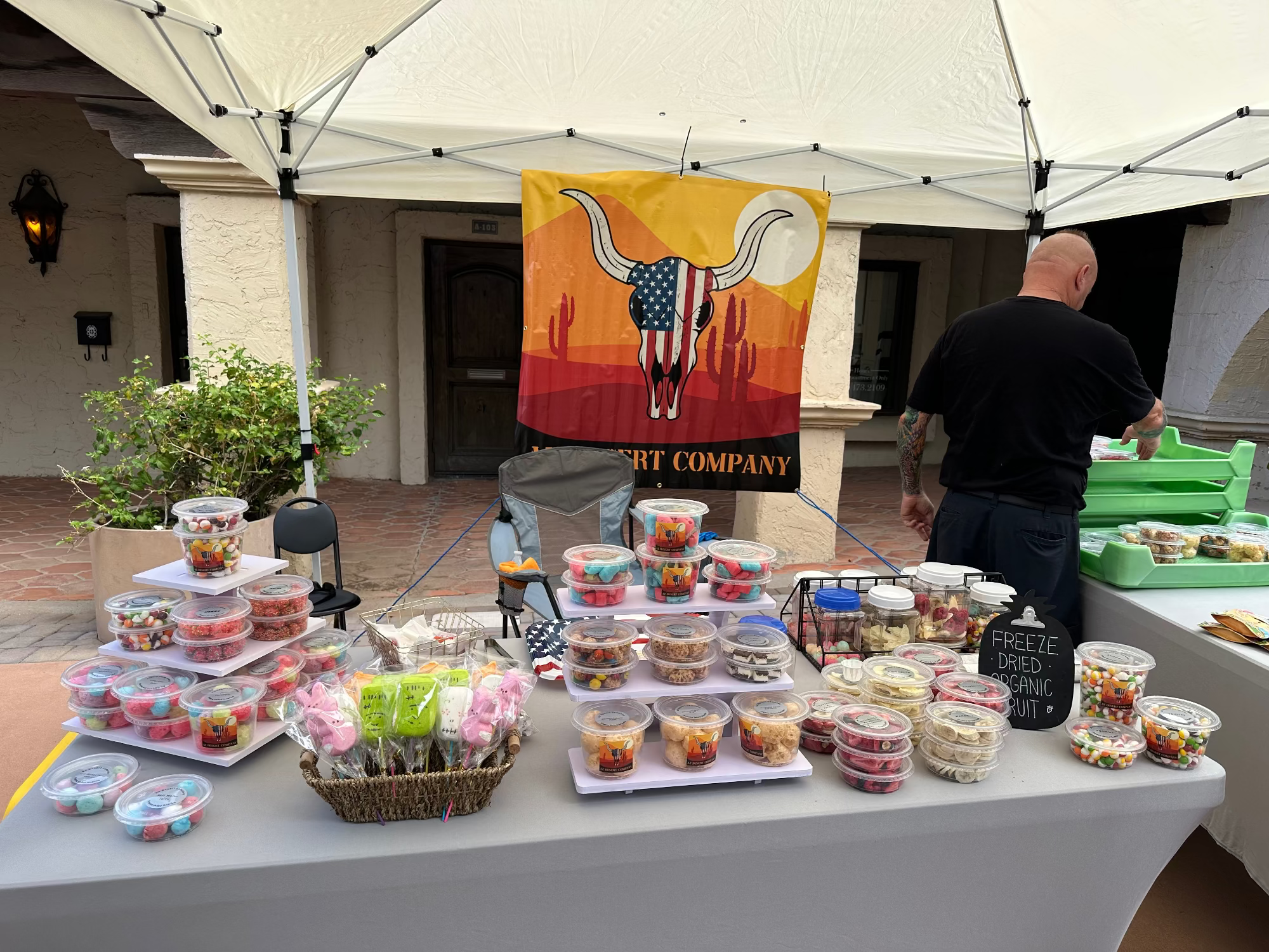 Outdoor event with freeze dried food display under a tent featuring a longhorn bull design.
