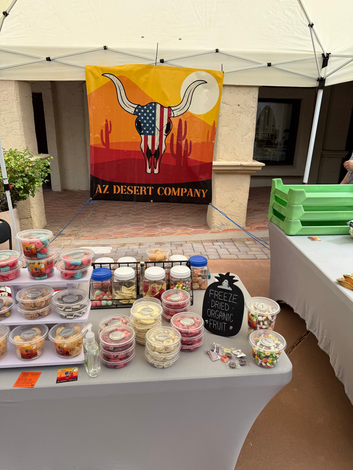 Outdoor event with freeze dried food display under a tent featuring 'AZ Desert Company' banner.