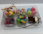 Small transparent box with colorful freeze dried snacks & candies on a white background