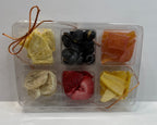 Assorted dried fruits in a transparent container on a white background