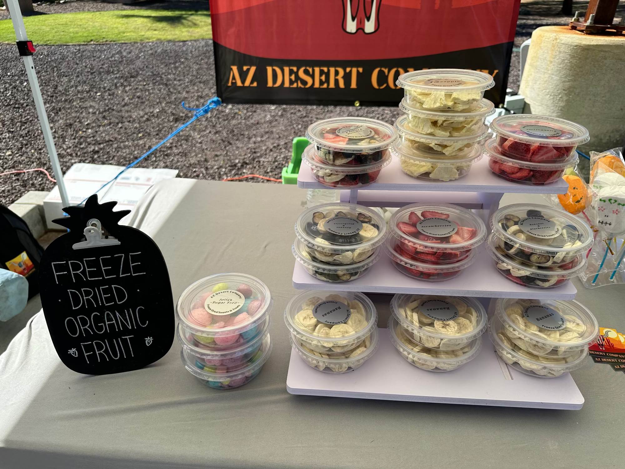 Freeze-dried organic fruit containers on a table with a sign indicating their type.